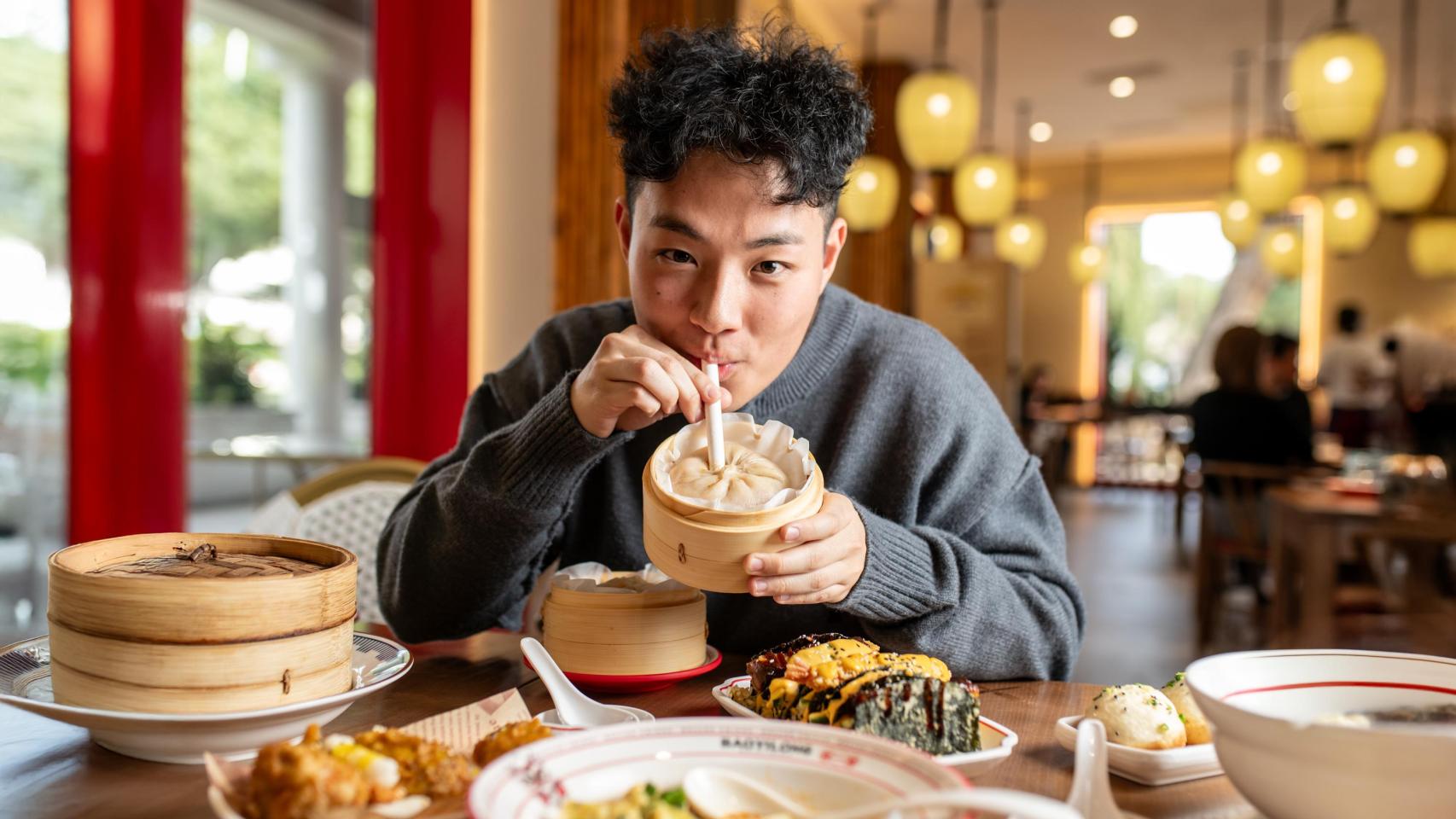 Diego Song bebiendo el bao gigante con pajita en el restaurante
