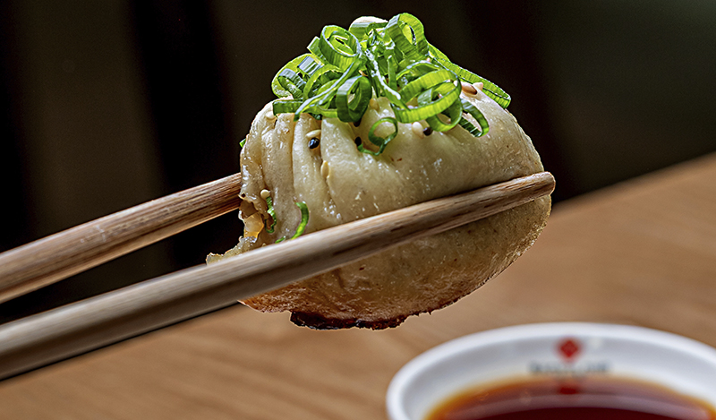 Sheng jian bao sujetado con palillos